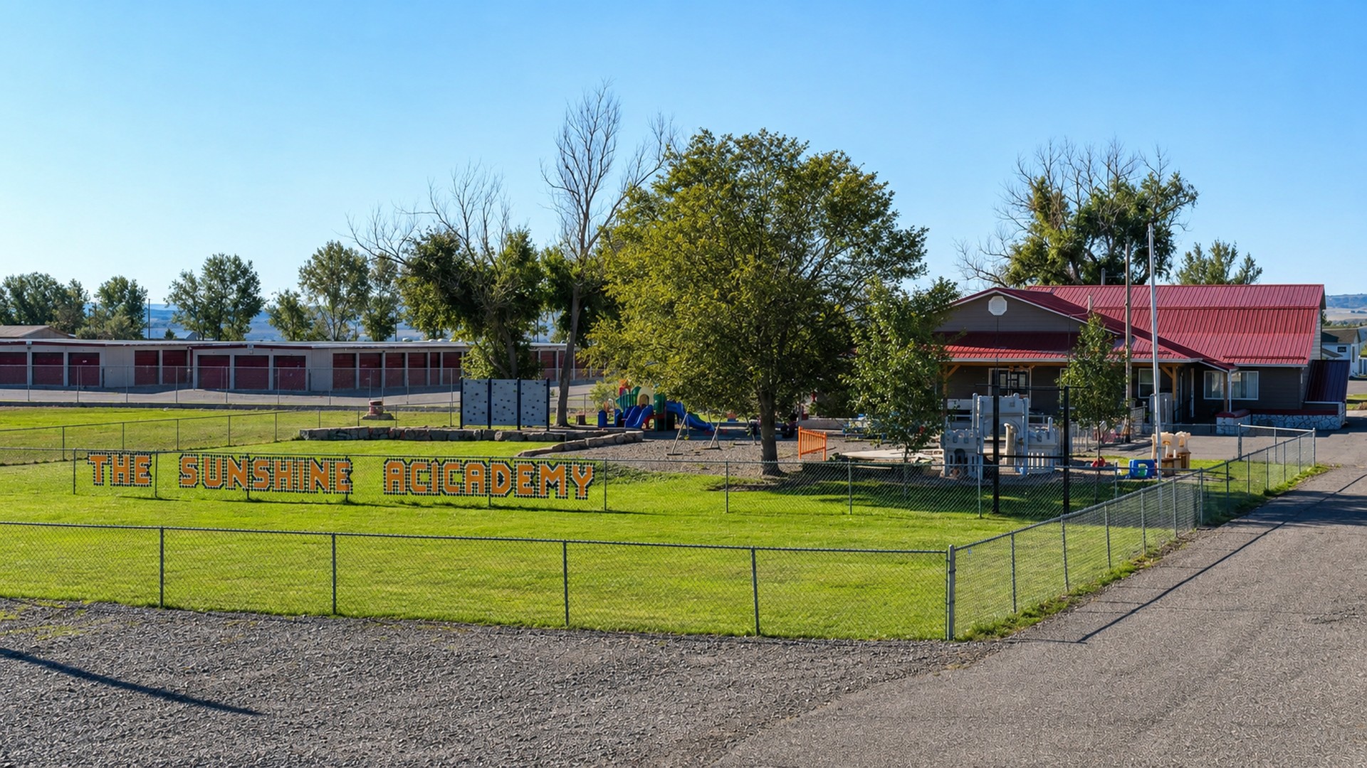 The Sunshine Academy Highway 312 daycare campus in Billings Heights, with a fenced playground and lawn sign